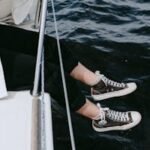 Woman relaxing on a yacht, enjoying the sea with legs dangling. Perfect summer leisure moment.